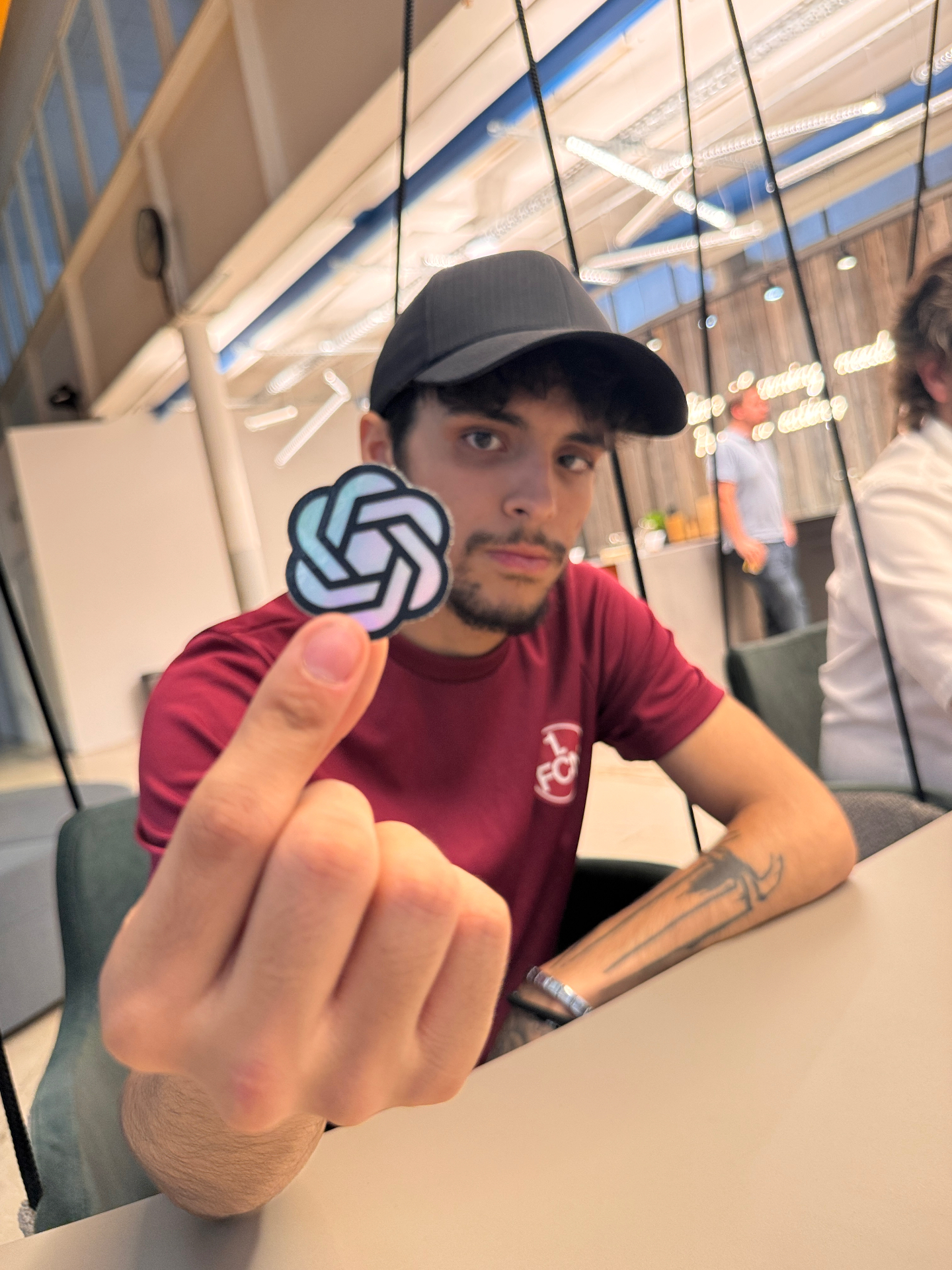 Tugay (TURANO), 22, mit weißem Hoodie und Hals-Tattoo